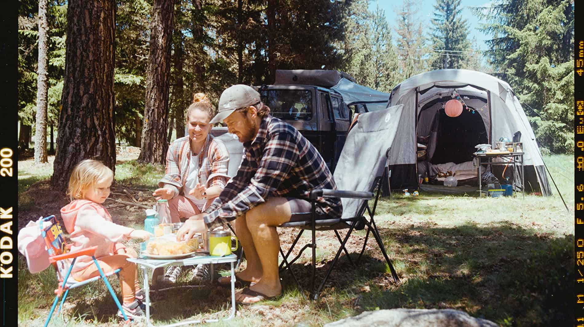Group of travellers relaxing on camping chairs by their vans — discover the 10 best camping chairs for road trips under £100