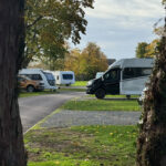 Riverside camping pitches at Chertsey Club Site London with camper vans and motor homes